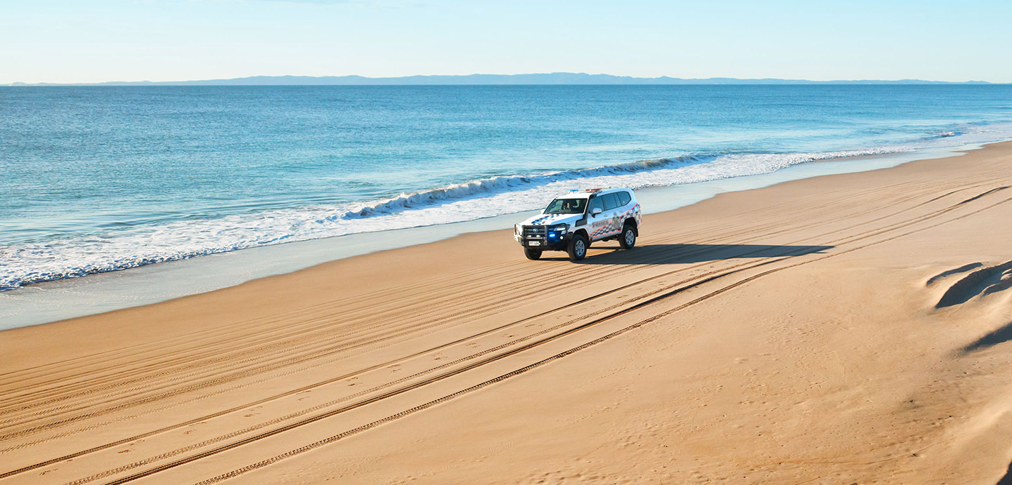 Queensland Police 4WD driving across beach