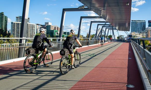 Two officers riding bikes on bridge