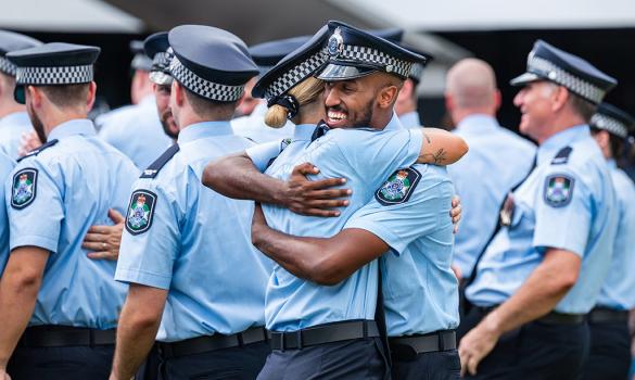 Queensland police recruits hug at graduation ceremony