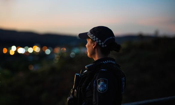 police officer looking to city lights at dusk