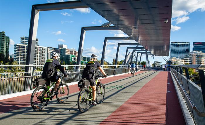 Police officers on bicycles crossing bridge