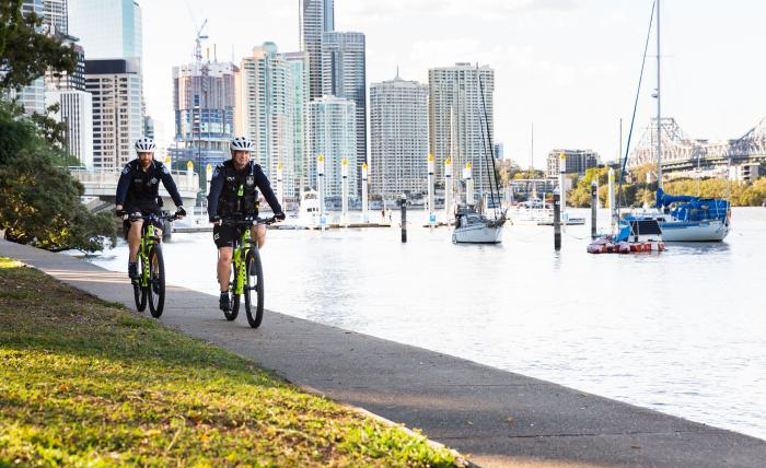 Two Queensland police officers cycling along Brisbane River bike path