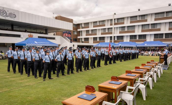 Queensland police recruits standing during induction ceremony in 2023