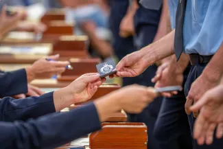 police recruits receive badges at graduation