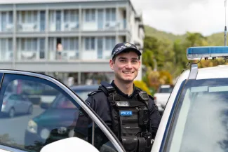 Smiling police officer getting into car