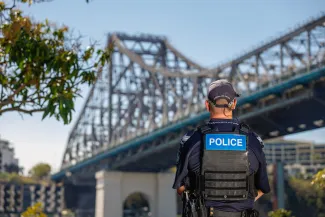 Police officer standing with Story Bridge in background